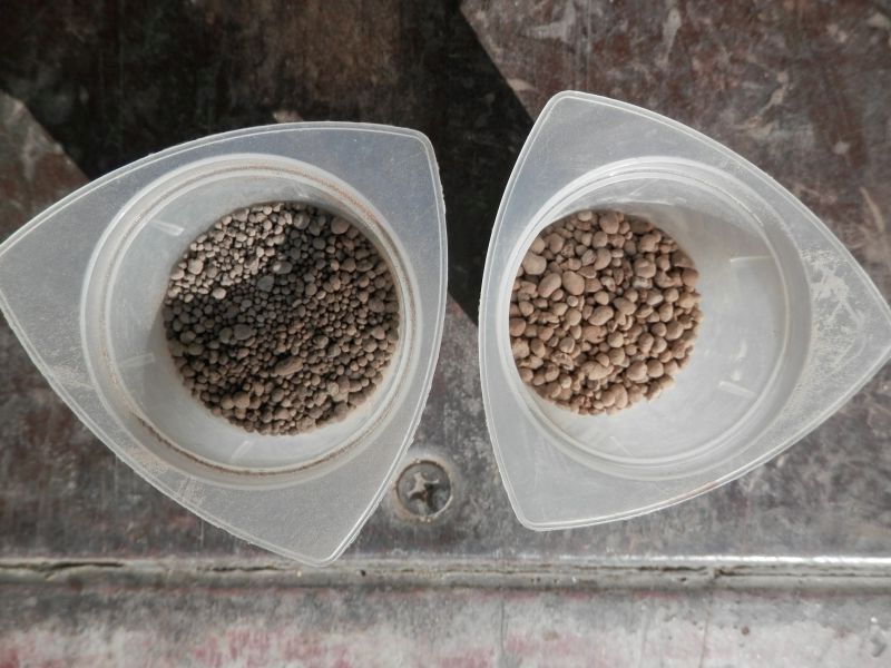 Two pelletized lime brands in beakers showing particle size difference